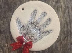 a handprint ornament with a red bow on it