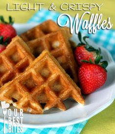 some waffles and strawberries on a white plate with the words light & crispy waffles