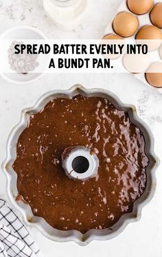 an overhead view of a cake pan with eggs in the background and text overlay that reads spread batter evenly into bundt pan