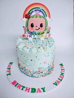 a birthday cake with sprinkles and a rainbow decoration