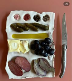 an assortment of different types of food on a plate with a knife next to it