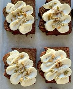 four pieces of bread with cream and nuts on them