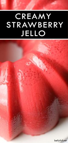 a close up of a strawberry jello cake on a plate with the words creamy strawberry jello