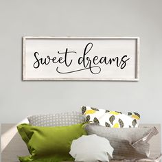 a sign that says sweet dreams above a bed