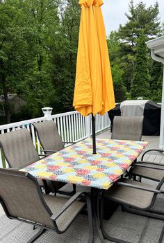 an outdoor table and chairs on a deck