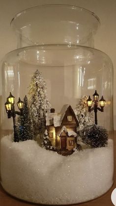 a glass jar filled with snow and small houses