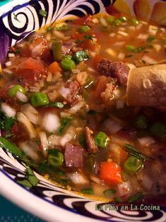 a bowl filled with soup and vegetables on top of a table