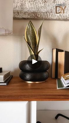 a wooden table topped with books and a potted plant