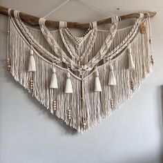 a white wall hanging with tassels and beads