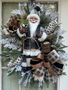 a christmas wreath with a santa clause and pine cones hanging on the front door window