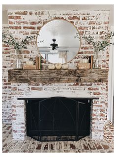 a fireplace with a mirror above it and some pumpkins sitting on top of the mantle