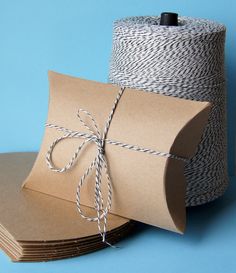 two rolls of twine are tied up next to each other on top of brown paper