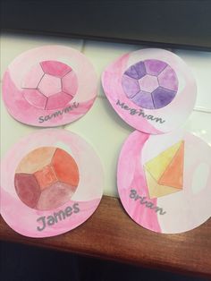 four paper plates with different shapes and names on them, sitting on top of a table