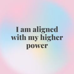 the words i am aligned with my higher power on a blurry blue and pink background