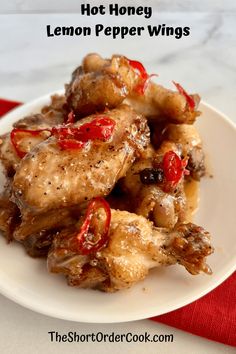 hot honey lemon pepper wings on a white plate with red and black napkin in the background