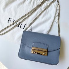 Furla Julia Mini Gray Blue Leather Crossbody Bag With Silver Hardware Closure. Removable Silver Tone Chain Shoulder Strap, 22.5" Drop. Flap Top With Pinch-Lock Clasp. Logo-Engraved Metal Bar. Interior Comes With Three Card Slots. Measures: 4.7"H X 6.8"W X 3"D Brand New Condition! Classic Blue Shoulder Bag With Chain Strap, Furla Bags, Engraved Metal, Bar Interior, Metal Engraving, Metal Bar, Mini Crossbody Bag, Mini Crossbody, 7 H