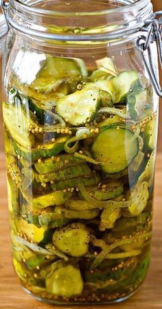 pickled cucumbers in a glass jar on a wooden table