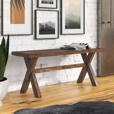 a wooden table sitting on top of a hard wood floor next to a white brick wall