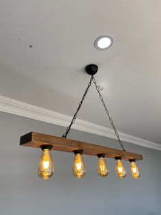 a wooden beam with five light bulbs hanging from it