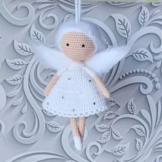 a crocheted angel ornament hanging from a string