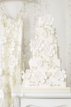 a wedding cake sitting on top of a white dresser