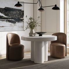 a white table with two chairs and a vase on it in the middle of a room