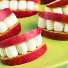 several red and white toothbrushes stacked on top of each other in an apple bowl