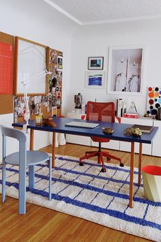 a living room filled with furniture and pictures on the wall next to a blue table