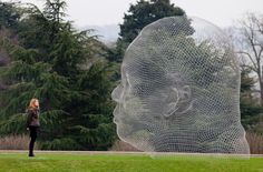 a woman is standing in front of a sculpture