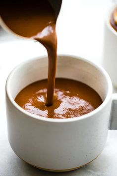 chocolate being poured into a white bowl