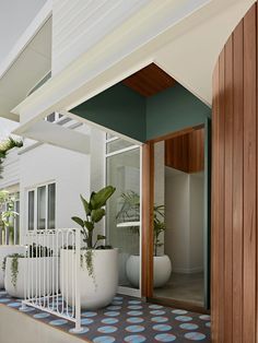 a house with potted plants on the front porch