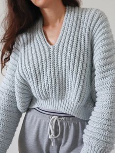 a woman wearing grey sweatpants and a sweater