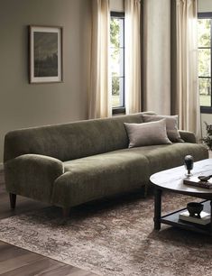 a living room scene with focus on the couch and coffee table in front of the window