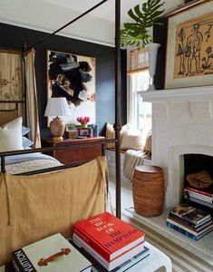 a bed room with a neatly made bed next to a fire place and a painting on the wall