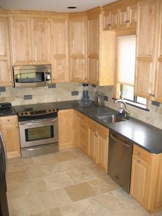 a kitchen with wooden cabinets and stainless steel appliances