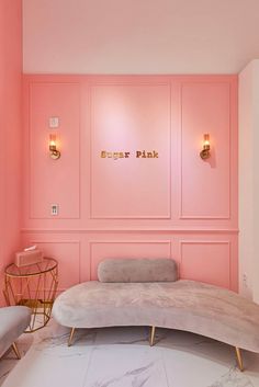 a room with pink walls and marble flooring in the center is an oval bench