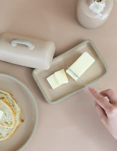 a person is pointing at some food on a plate with cheese and bread in it