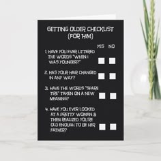 a black greeting card with the words getting older checklist form him on it next to a plant