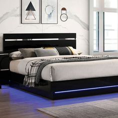 a bed that has some lights on the headboard and night stands in front of it