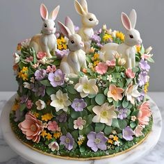 an elaborate cake decorated with flowers and rabbits