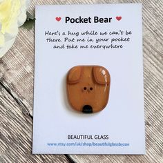 a brooch with a dog face on it's front and the words pocket bear above it