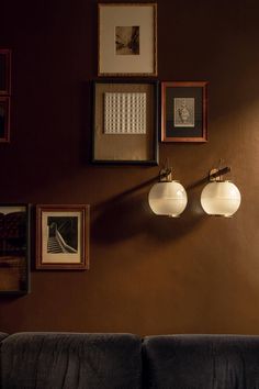 a living room with two couches and pictures on the wall above them in various frames