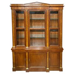 an old wooden bookcase with glass doors on the front and bottom shelves, isolated against a white background