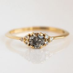 a yellow gold ring with three diamonds on the top and one diamond in the middle