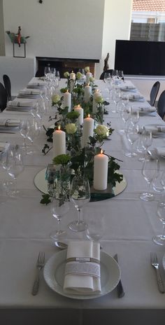 a long table is set with candles and place settings