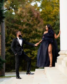 a man in a tuxedo and a woman in a black dress holding hands