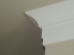 the corner of a wall with a white crown moulder on it's side