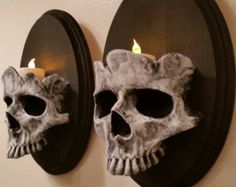 two skulls are mounted to the wall with candles