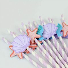 there are many paper straws with starfish designs on them and one is pink, purple, and blue