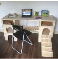 a laptop computer sitting on top of a wooden desk next to a chair and book shelf